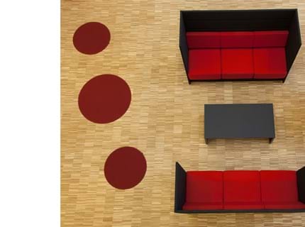 røde og runde filttæpper ved sofa