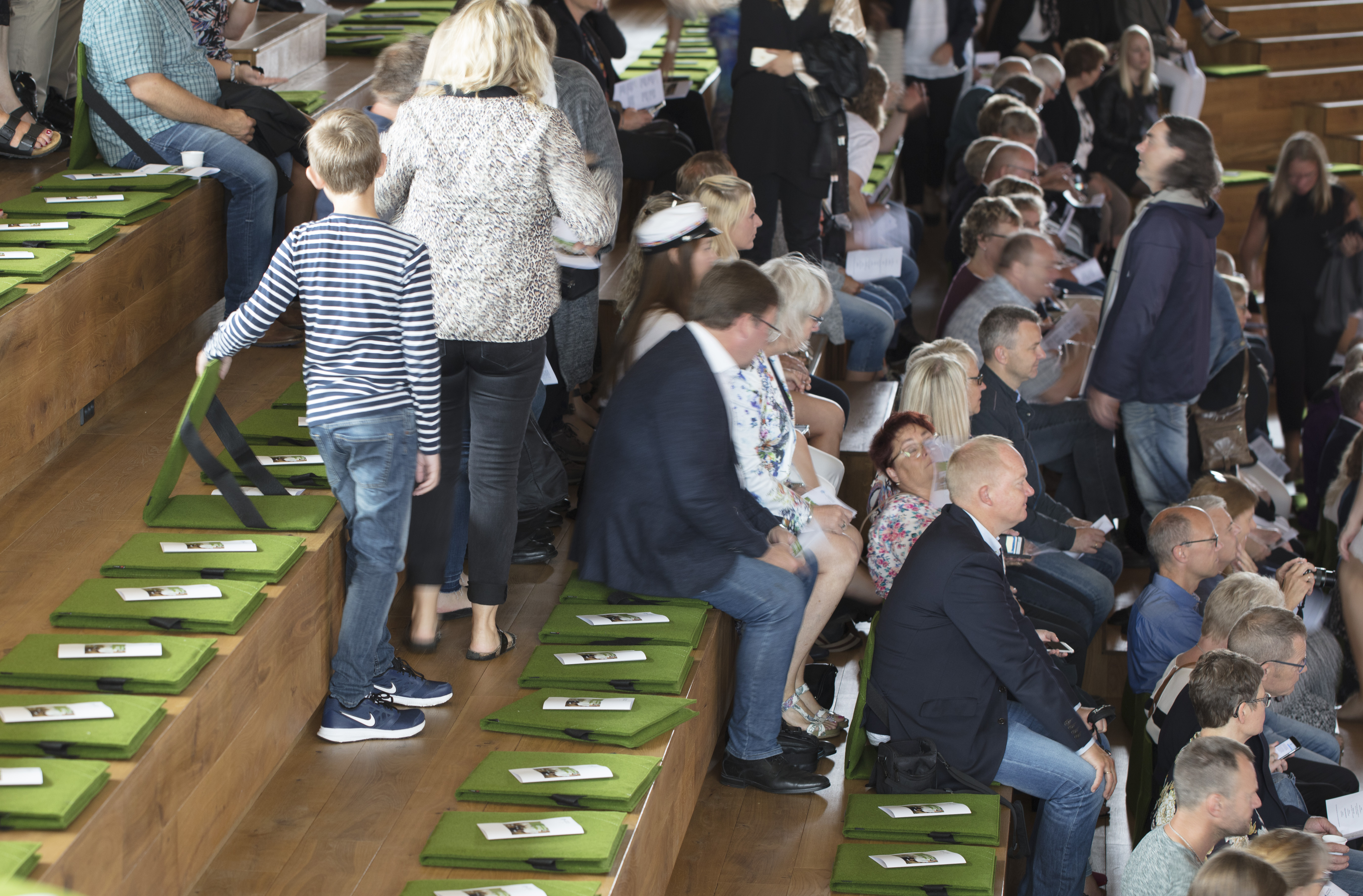 Fold ud stol i grøn filt i auditorium