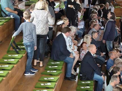 Fold ud stol i grøn filt i auditorium
