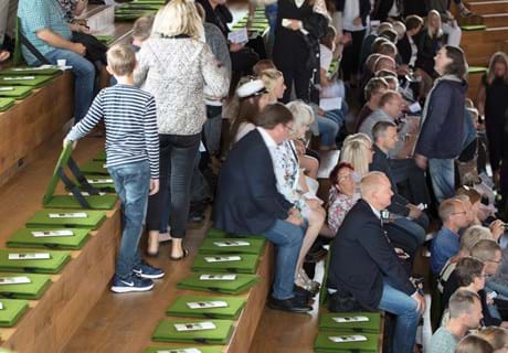 Fold ud stol i grøn filt i auditorium