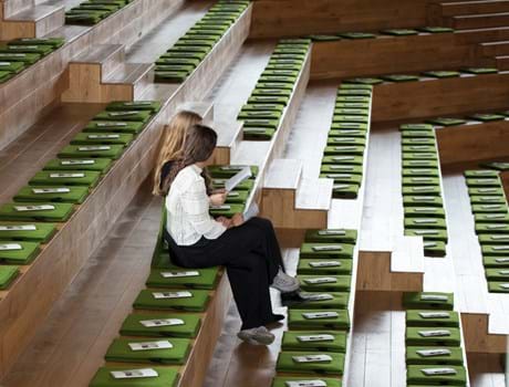 Fold ud stol i grøn filt i auditorium