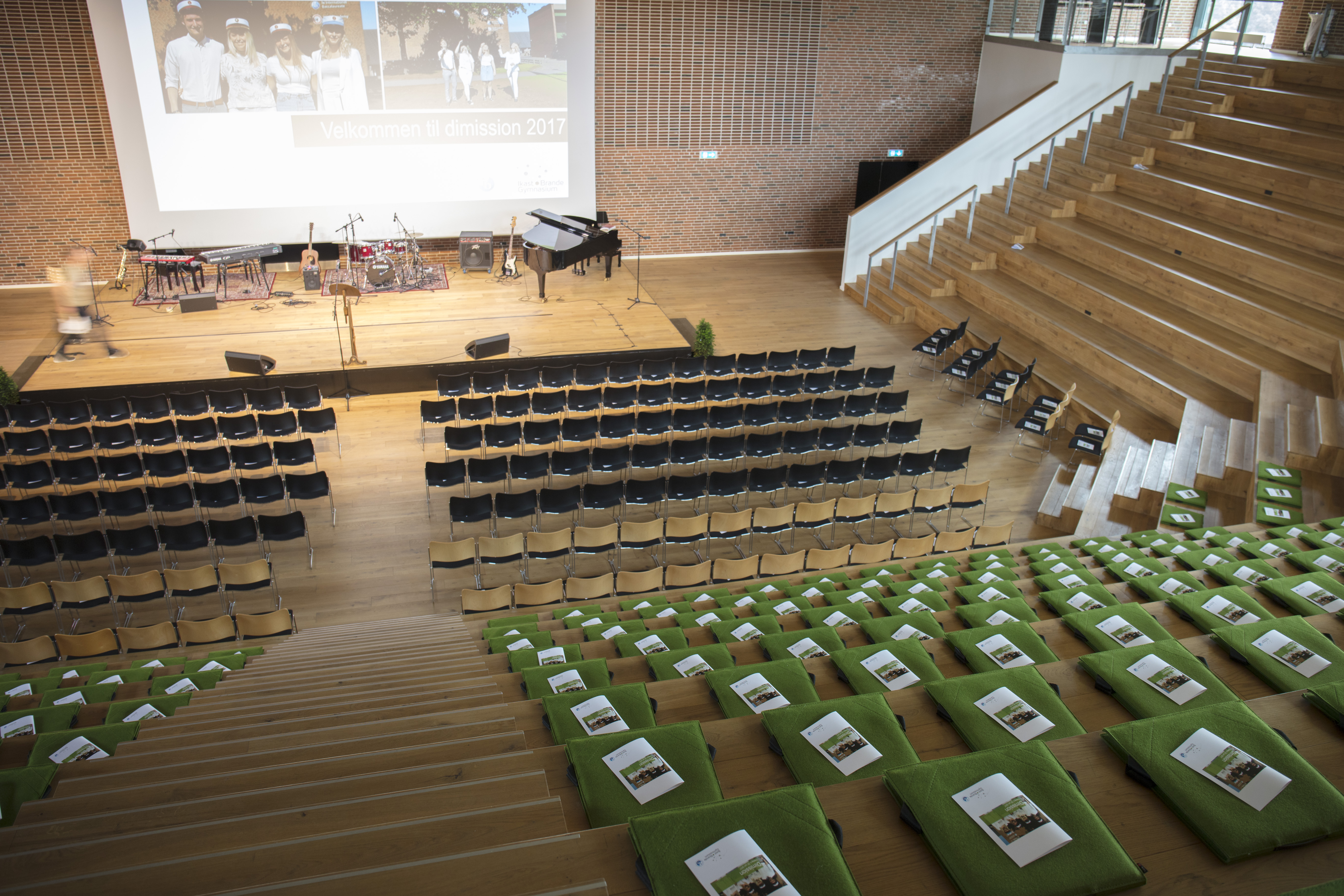 Fold ud stol i grøn filt i auditorium