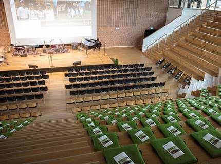 Fold ud stol i grøn filt i auditorium