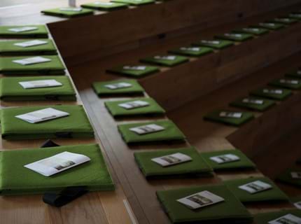 Fold ud stol i grøn filt i auditorium