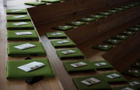 Fold ud stol i grøn filt i auditorium