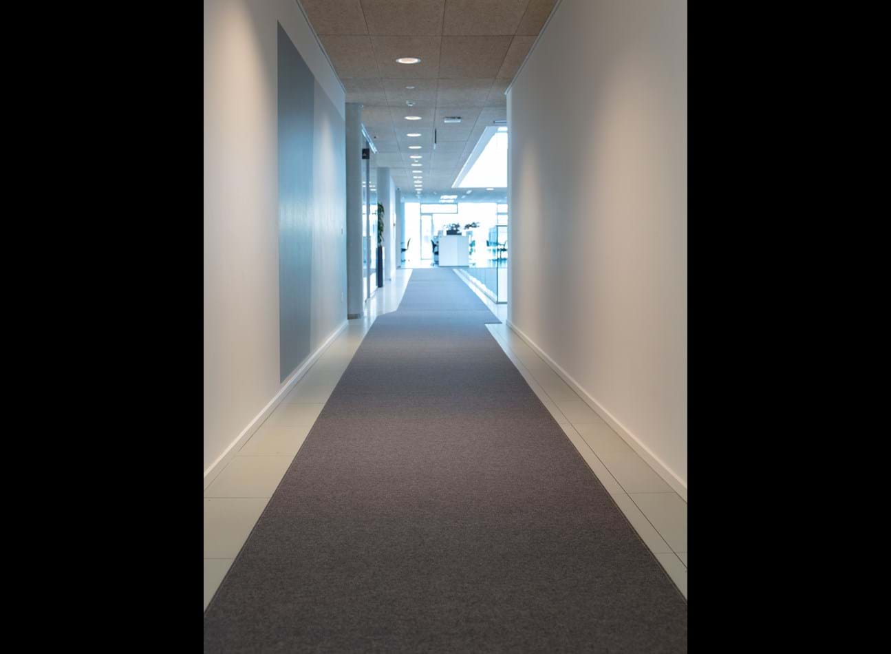Løber i grå filt på lang kontorgang